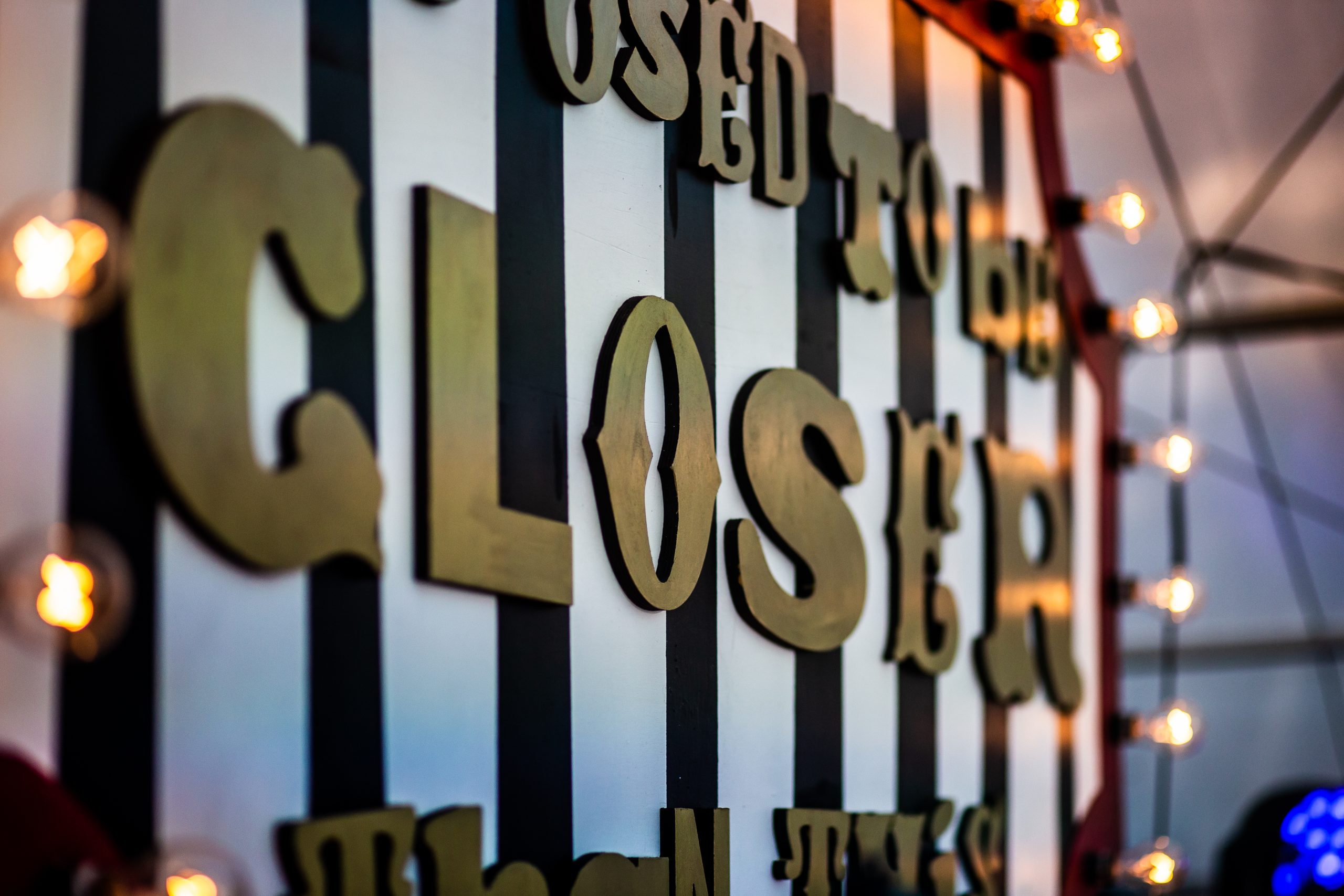 A sign of the show title on black and white striped background, as part of the set