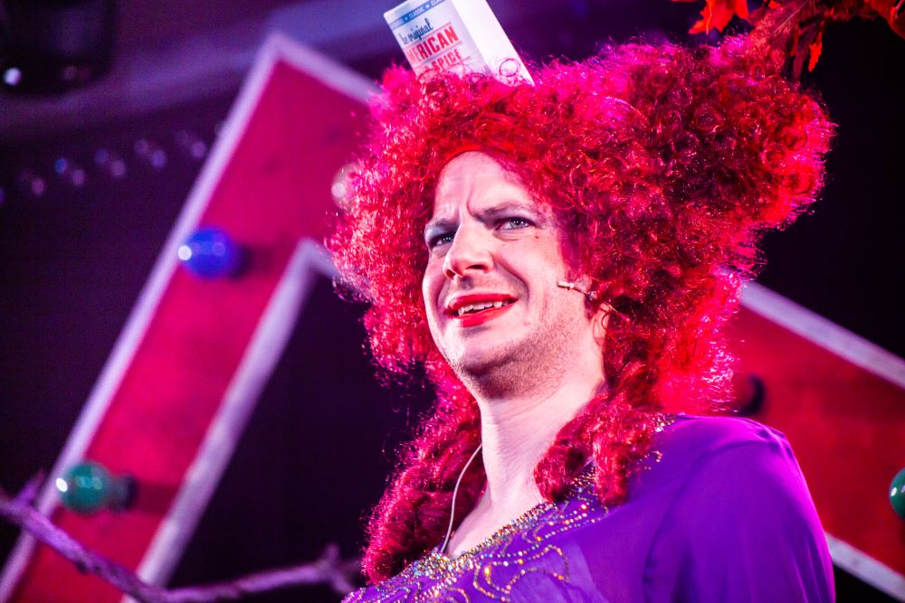 Hull panto dame Pattie Breadcake, in red baroque wig and purple dress