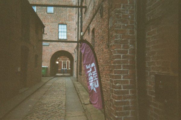 An empty alleyway has a purple flag reading 'Middle Child'.