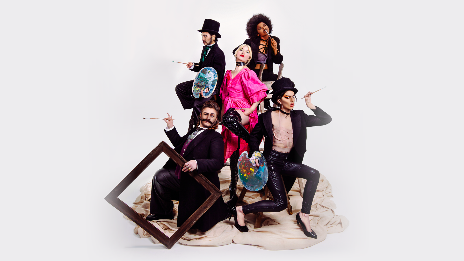 A woman in vivid pink Victorian dress stands confident and cocksure with her hand on her hip, surrounded by four drag kings in tail coats. Two of the drag kings wear top hats, another has Afro hair style and another a long flowing mullet. The four drag kings variously hold paintbrushes, an empty picture frame and messy paint palettes.